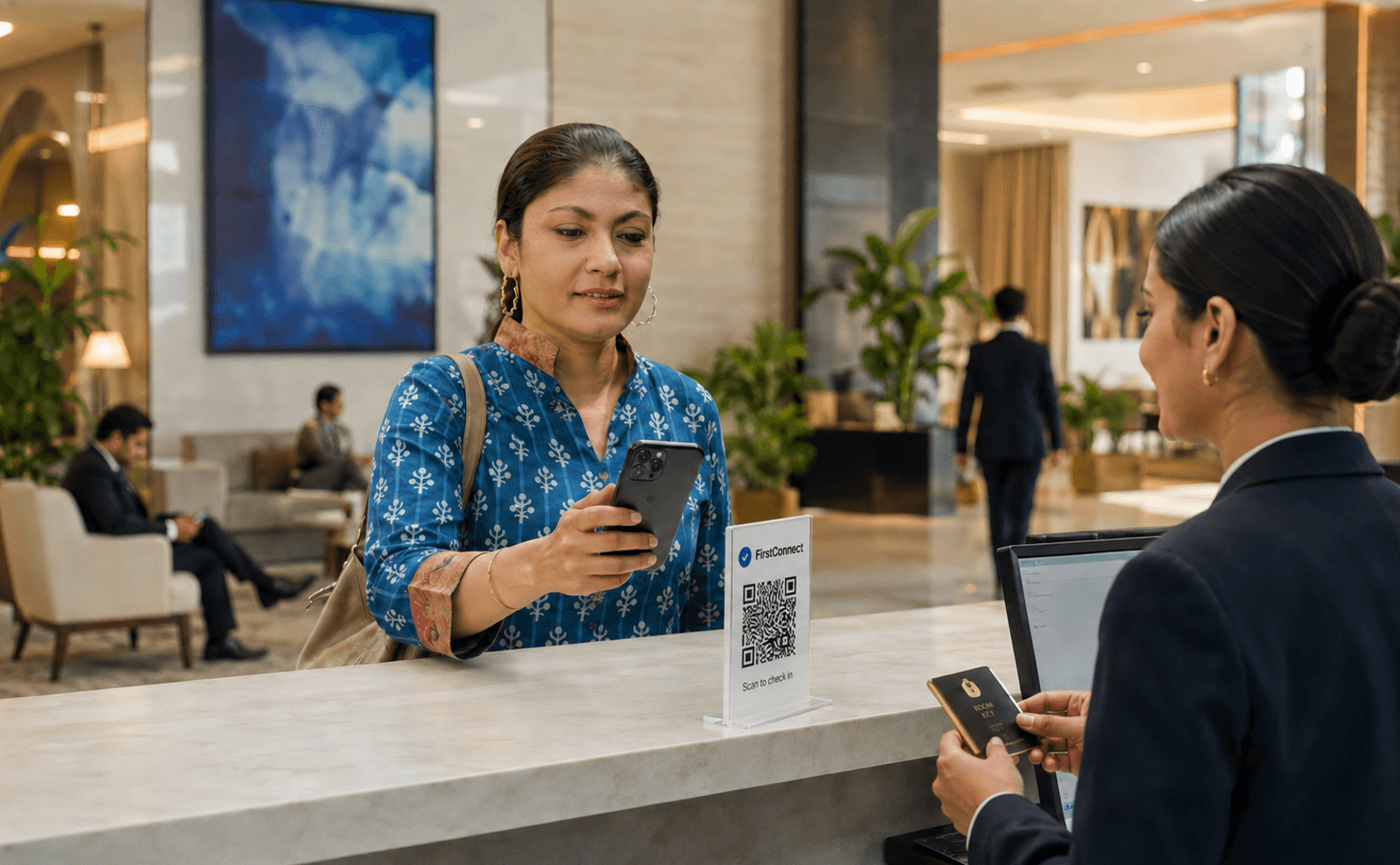 Guest reviewing a phone while a receptionist checks arrival details at the hotel desk